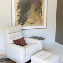 Designer reading nook with custom lounge chair, ottoman and contemporary artwork in a luxury Tulsa residence.