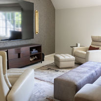 High-end media room designed for entertaining featuring custom furnishings, textured wallcovering and contemporary lighting.
