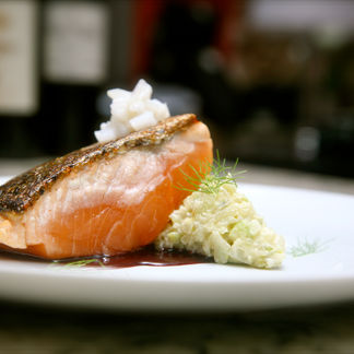 Salmón a la plancha en costra de pimienta, risotto de hinojo, calamar y salsa de vino tinto.