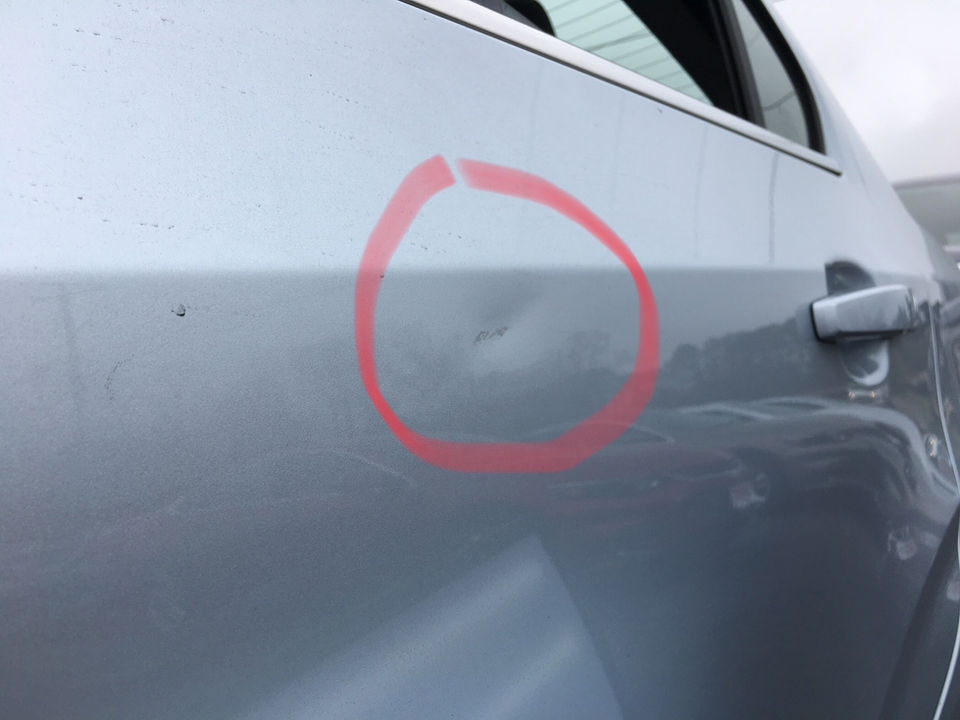 dent on left rear door of chevy sedan