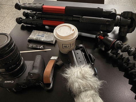 A visual content producer’s kit lies out on a table in front of them, ready for a busy day of filming content for a client.