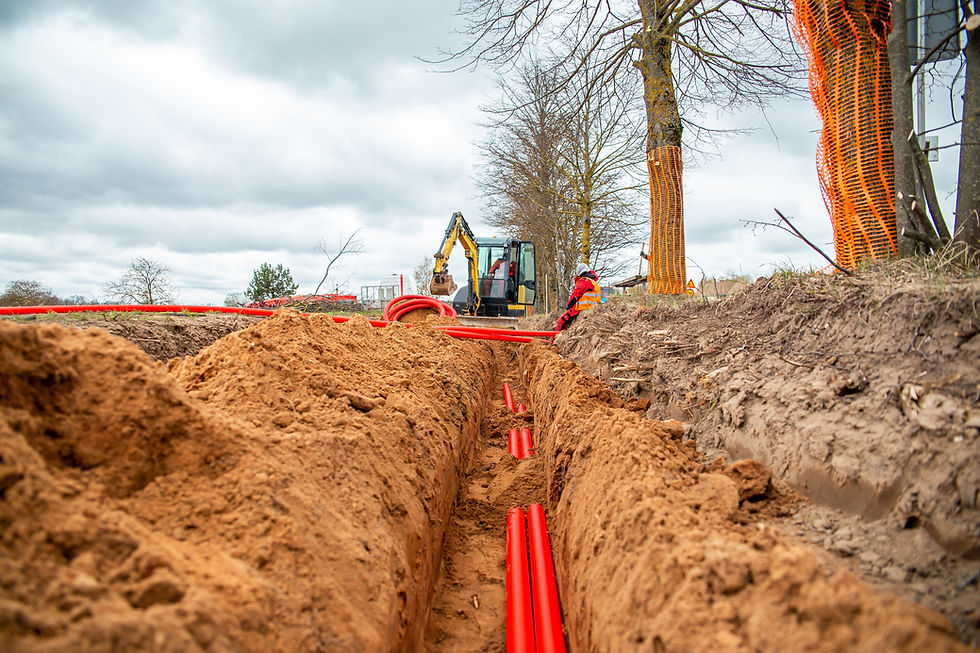 Network cables in red corrugated pipe are buried underground on the street. underground el