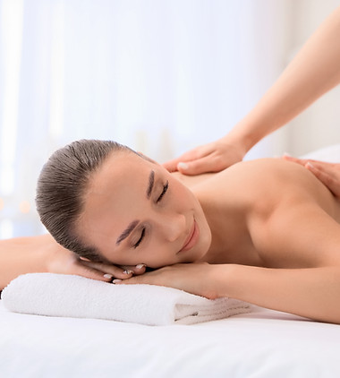 Relaxed young woman getting massage by therapist in spa salon.jpg