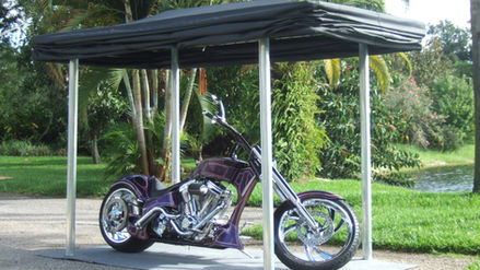 Dark Colored freestanding motorcycle cover in the up position