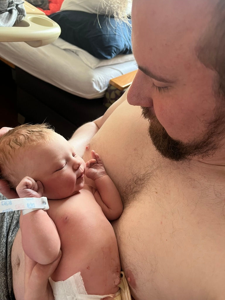 A wee baby with dainty lady hands and her burly dada.