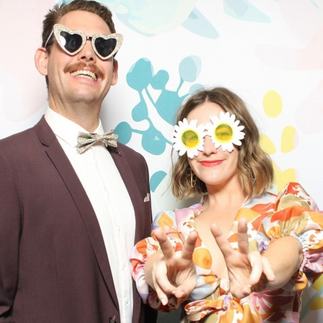 Man and woman standing in front of an open air photo booth at a venue in Adelaide