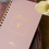 Thumbnail: A pink spiral-bound 'With Every Breath' prayer journal with gold foil lettering.