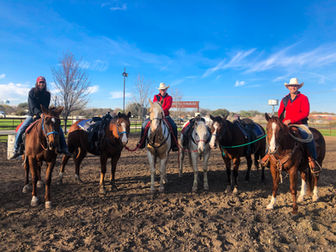 Staff at Benbrook Stables in the arena on their horses