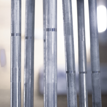 Close-up of barbells standing upright in a rack