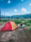 a woman sitting by her tent camping alone