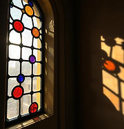 stained glass gaudi style with rondels sun reflecting through window, less sun and more th