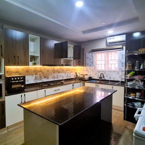 Modern kitchen with wooden cabinets, built-in appliances, and a central island.