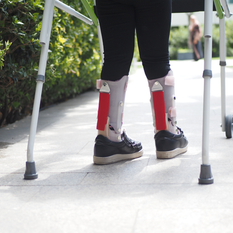 Child's legs with pediatric orthotics and a walker