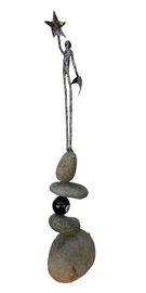 Metal man standing on boulders holding the moon in one hand and a start in their upstretched other hand. 