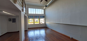 The first room of the gallery with beautiful wood flooring and lots of natural lighting from the windows.