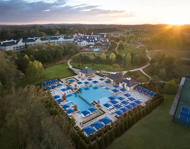 The NEW Resort Pool on the grounds of Salamander Middleburg in Virginia horse country, featuring an elegant country estate design with stone balconies and scenic Blue Ridge Mountain foothills.