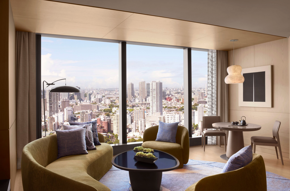 Luxury hotel suite living area with floor-to-ceiling city views, modern furnishings, and designer lighting — representing the upscale segment driving U.S. hotel RevPAR growth amid a widening K-shaped demand divergence in hospitality investment markets.