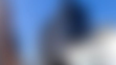 Glass-curtain-wall commercial office buildings along an urban street, representing mixed-use and commercial real estate asset classes analyzed in SBA and USDA loan underwriting.