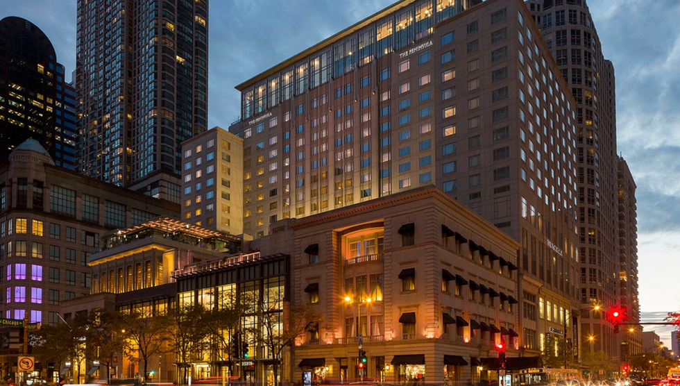 Full-service hotel tower rising above a busy downtown intersection — the kind of high-density hospitality asset where zero-foot setbacks, unlimited FAR, and eliminated parking minimums make development feasible in 2026.