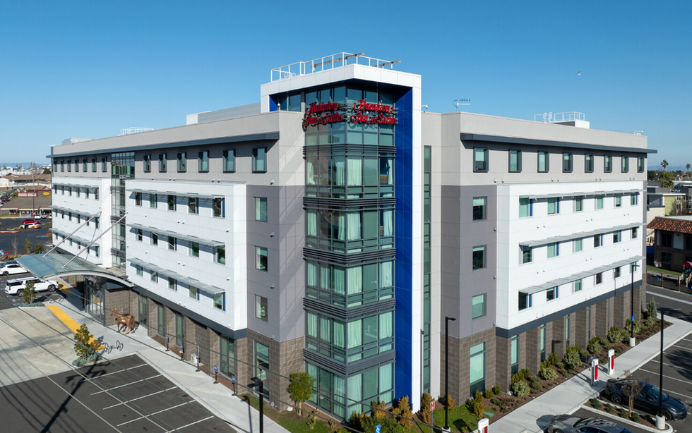 Exterior view of a Hampton Inn & Suites hotel building.