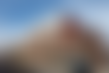 Urban mixed-use commercial building undergoing rooftop remediation with boom lift and containment sheeting, illustrating Phase II ESA and environmental abatement in active redevelopment.