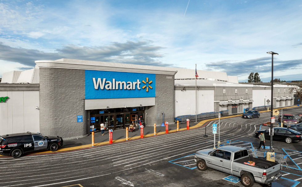 Exterior of a full-service grocery anchor with front parking field, accessible stalls, and cart corrals along the storefront.