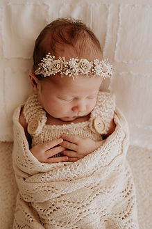 a newborn baby sleeping in a cute wrap photography shoot