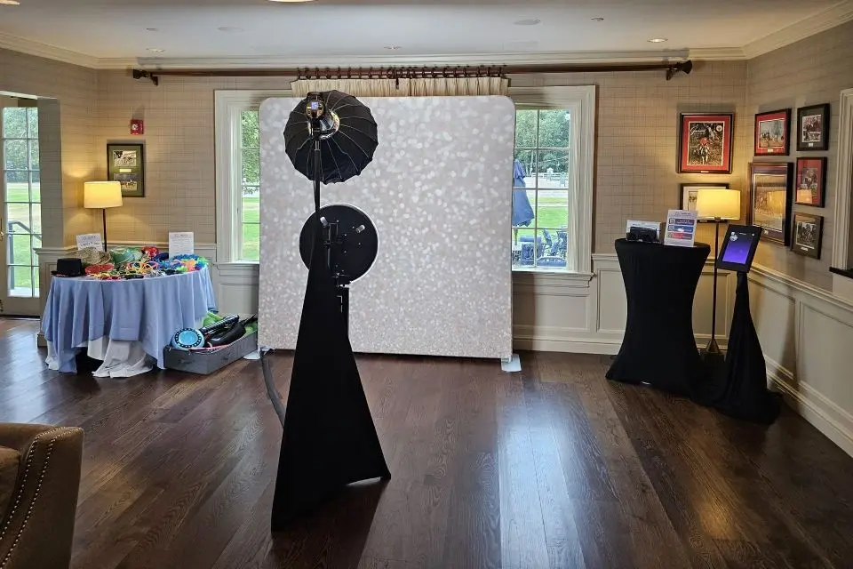 photo booth set up at Fairfield County Hunt Club with studio lighting, printed photos, and digital share station