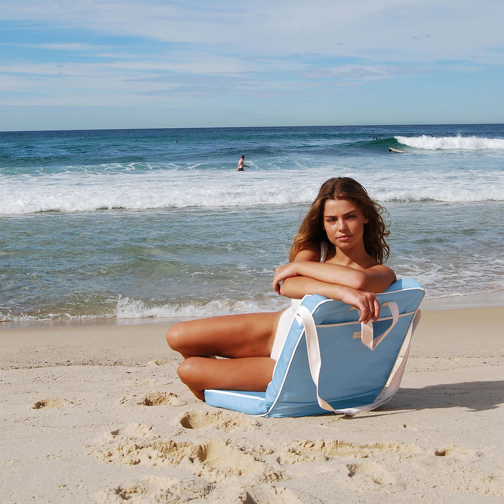 La Mer Med Blue folding beach chair styled on a sandy beach