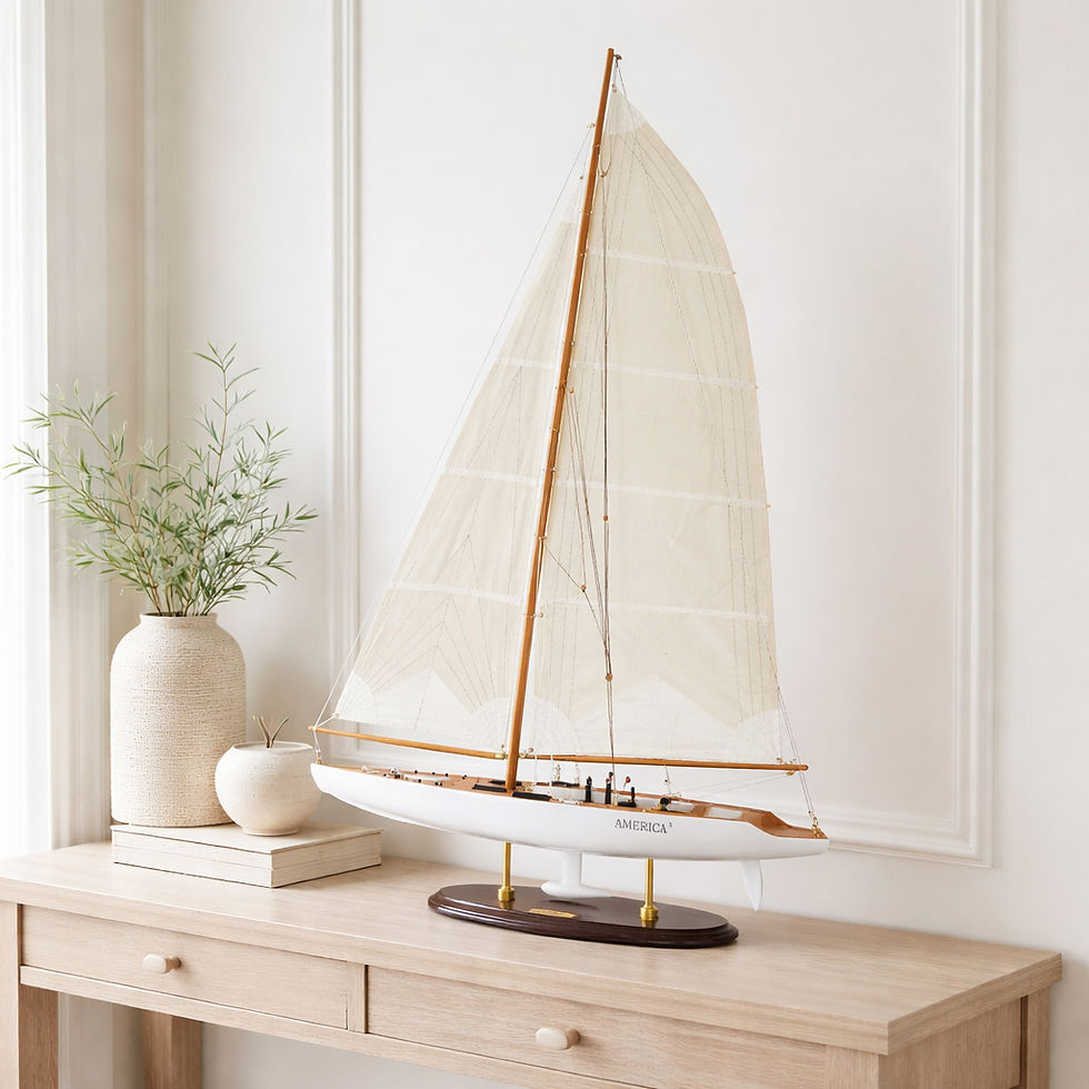 Large America III yacht model displayed on a light wood sideboard in a bright coastal home office