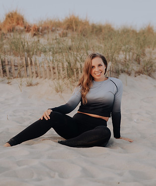 Lisa Torswick sitting in the sand on the beach.