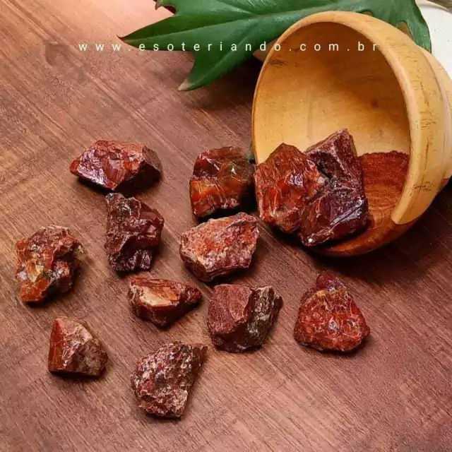 Mesa de madeira natural. pedras brutas naturais de calcita vermelha, potinho de madeira e folha de costela de adão