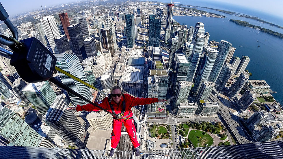 Arms out, 356 metres up — the entire Toronto skyline stretched out below