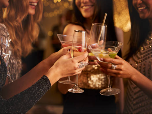 Women raising glasses to toast together.