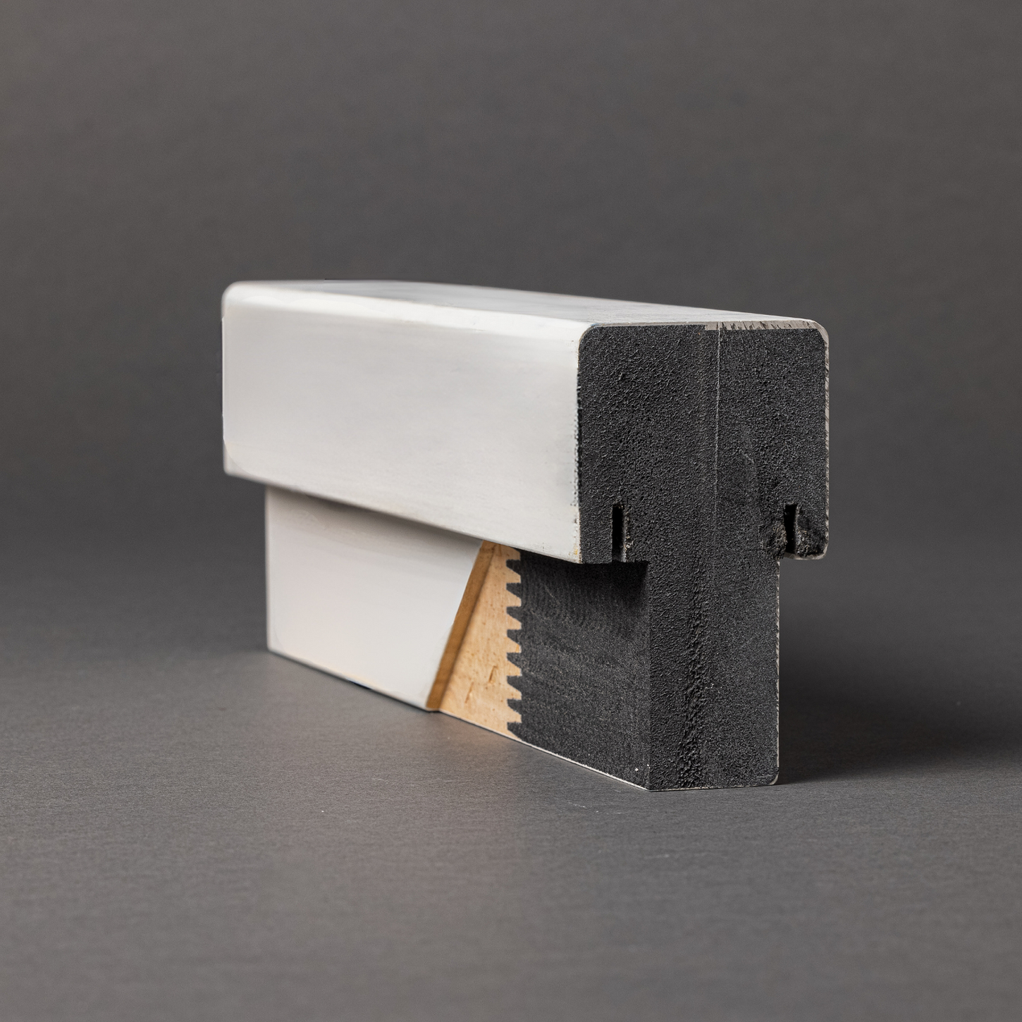 Close-up of a ProtecDoor mull post with a white Vindex finish on a gray background.