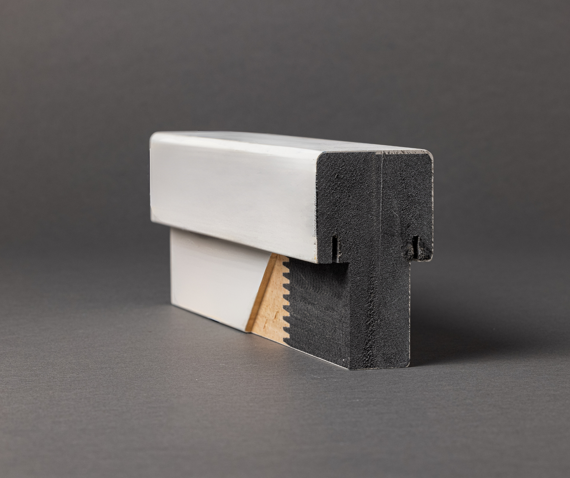 Close-up of a ProtecDoor mull post with a white Vindex finish on a gray background.