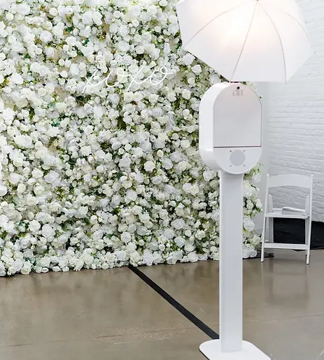 Open-air photo booth at a luxury event with professional studio lighting, modern backdrop, and guests posing for high-quality photos at a wedding, corporate event, or brand activation.