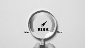 A magnifying lens highlights the risk levels on a dashboard.