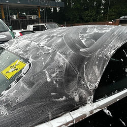 Black convertible car roof covered in suds, 'EASY TO FIND' sticker.