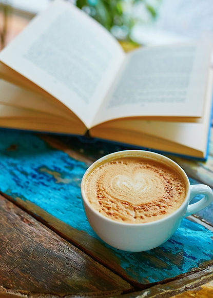 Cup of fresh coffee and book on a wooden table