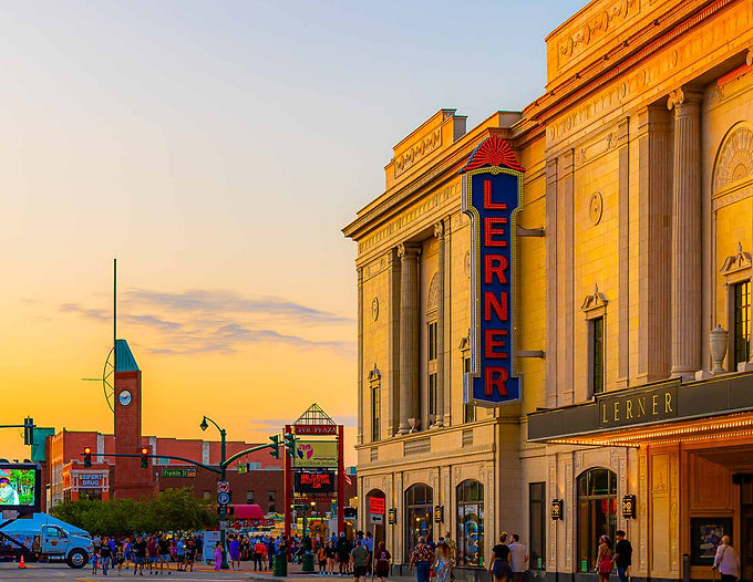 Exterior view of the learner theatre and downtown elkhart at sunset, with people walking around.