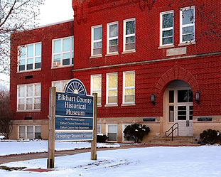 Exterior of the Elkhart County Historical Museum in Bristol, Indiana, showing the red brick museum building and entrance sign during winter.