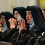 				Las hermanas carmelitas rezan durante la Misa para concluir nueve días de luto por el papa Francisco. (Foto: Daniel Petty)				