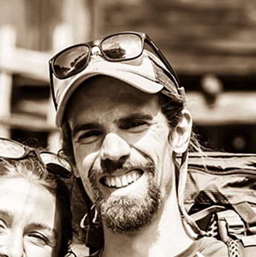 Monsignor Bernie Schmidt gives a blessing at the altar, surrounded by candles and a gathering.