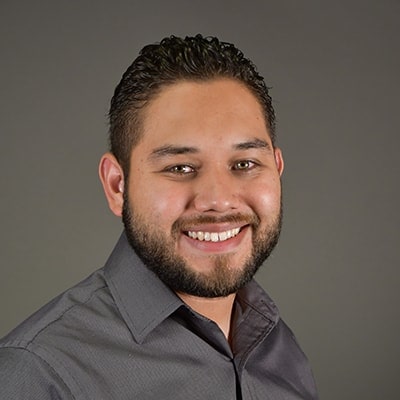 Monsignor Bernie Schmidt gives a blessing at the altar, surrounded by candles and a gathering.