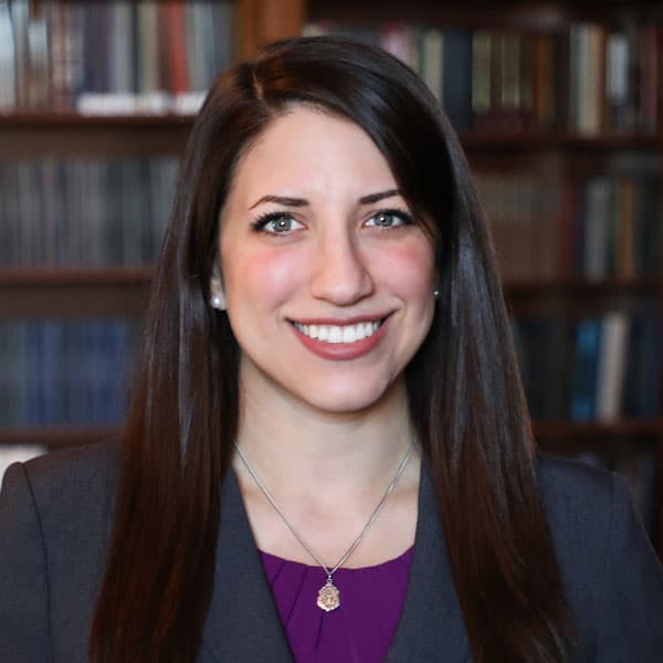 Monsignor Bernie Schmidt gives a blessing at the altar, surrounded by candles and a gathering.