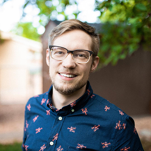 Monsignor Bernie Schmidt gives a blessing at the altar, with candles surrounding him.