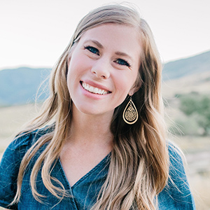 Monsignor Bernie Schmidt gives a blessing at the altar, surrounded by candles and a gathering.