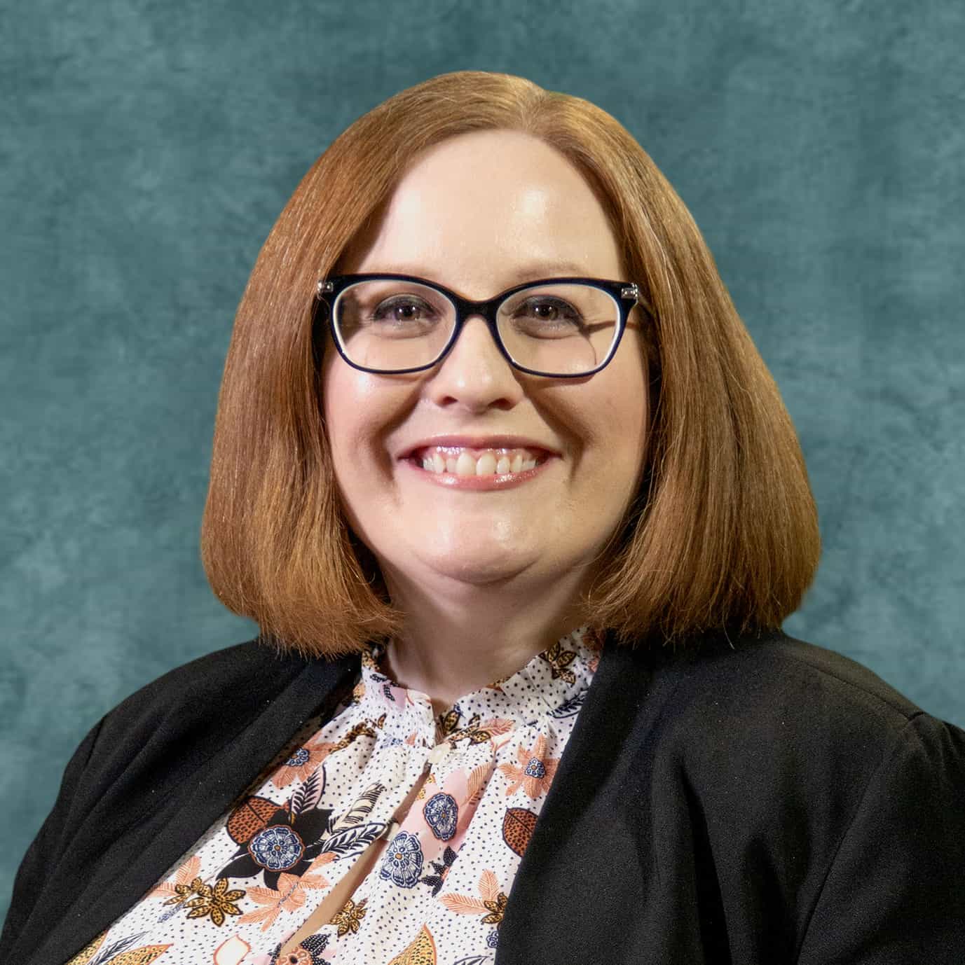 Monsignor Bernie Schmidt gives a blessing at the altar, surrounded by candles and a gathering.