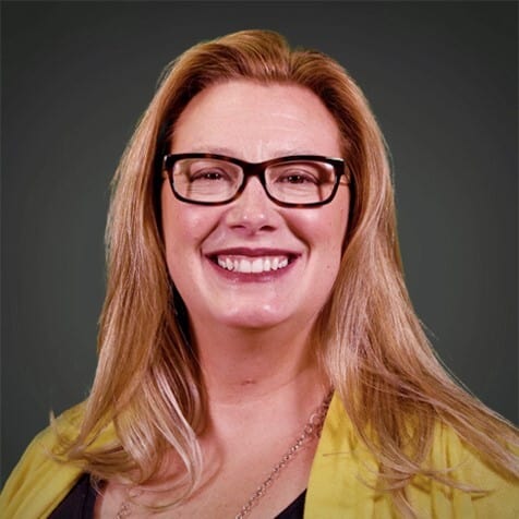 Monsignor Bernie Schmidt gives a blessing at the altar, with candles surrounding him.